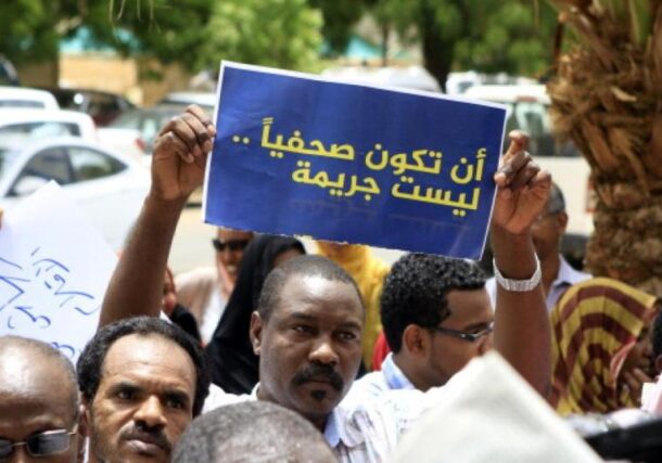 A Sudanese journalist holds a banner reading, "To be a journalist is not a crime," in this file photo.