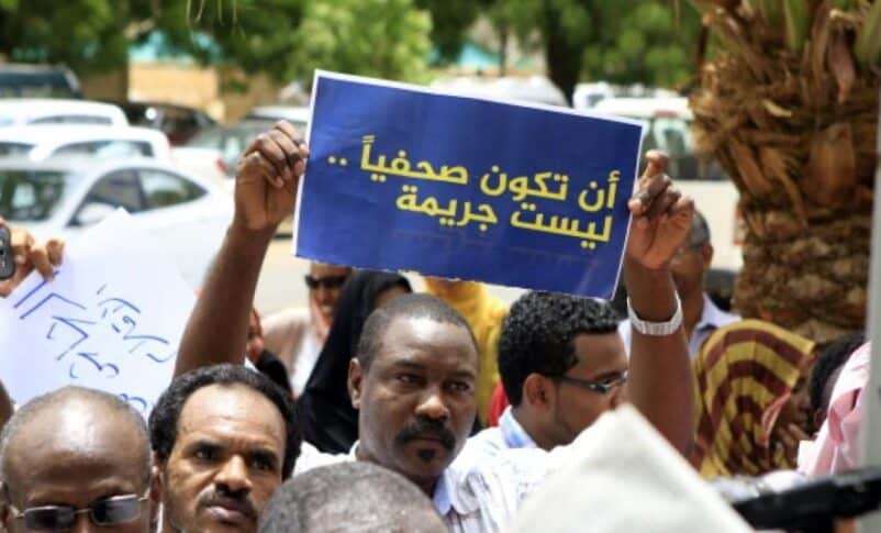 A Sudanese journalist holds a banner reading, "To be a journalist is not a crime," in this file photo.