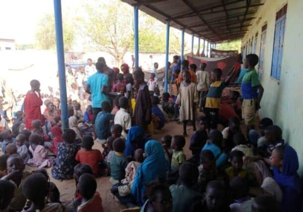 Displaced people wait for meals to be distributed at a shelter in El Fasher, Sudan, in this file photo from June 3, 2025.