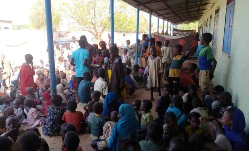 Displaced people wait for meals to be distributed at a shelter in El Fasher, Sudan, in this file photo from June 3, 2025.