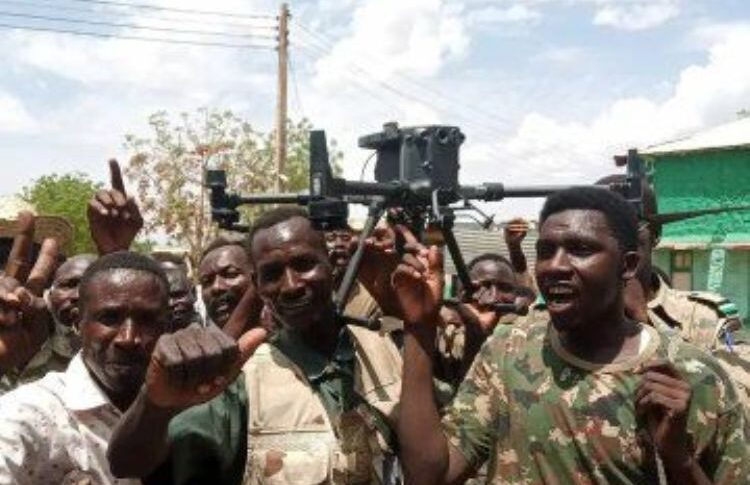 Sudanese soldiers hold a drone captured in Dilling on June 25, 2025