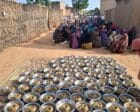 Civilians at a community kitchen in El Fasher wait for meal distribution on July 25, 2025