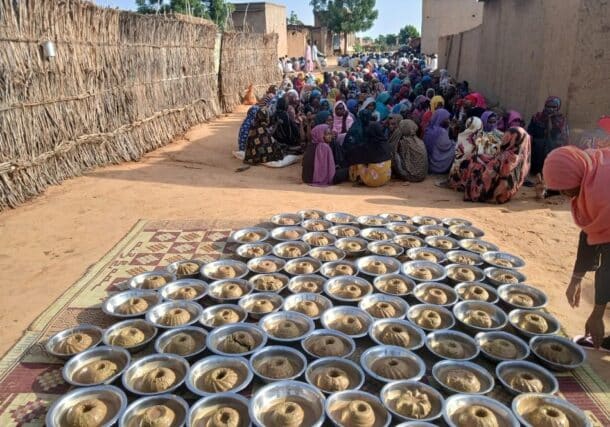 Civilians at a community kitchen in El Fasher wait for meal distribution on July 25, 2025