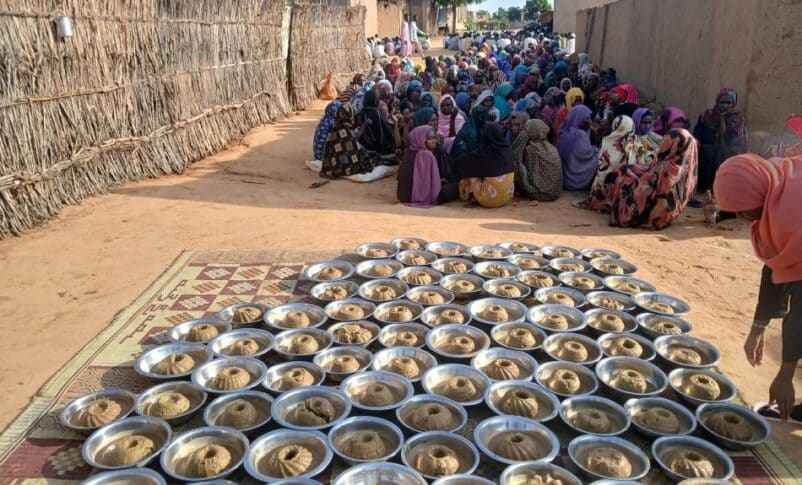 Civilians at a community kitchen in El Fasher wait for meal distribution on July 25, 2025