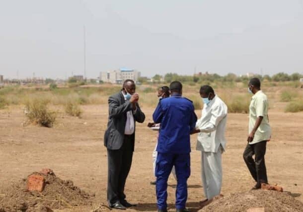 Judicial officers oversee the exhumation of a mass grave containing RSF victims at a university in Wad Madani, on July 14, 2025.