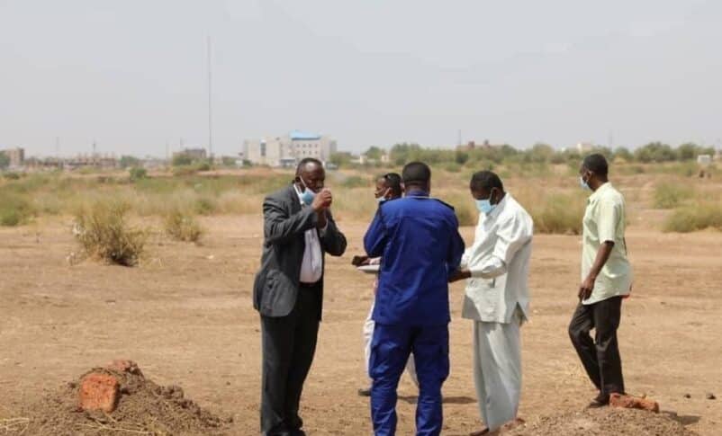 Judicial officers oversee the exhumation of a mass grave containing RSF victims at a university in Wad Madani, on July 14, 2025.