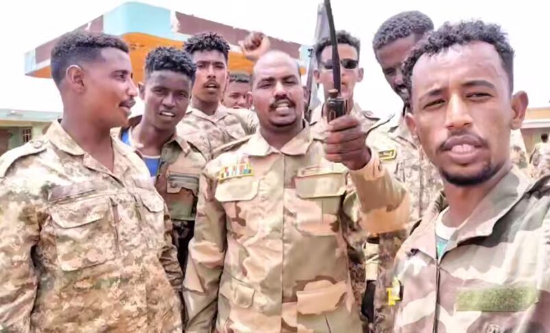 A commander of the Sudan Shield Forces gestures as he stands with his fighters near the site of a deadly drone attack in Tumbul, Sudan, August 13, 2025