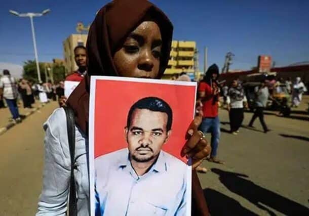 A woman holds a picture of slain Sudanese teacher Ahmed al-Khair following a court verdict in his murder case in Omdurman, Sudan, January 30, 2020.