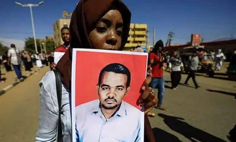A woman holds a picture of slain Sudanese teacher Ahmed al-Khair following a court verdict in his murder case in Omdurman, Sudan, January 30, 2020.