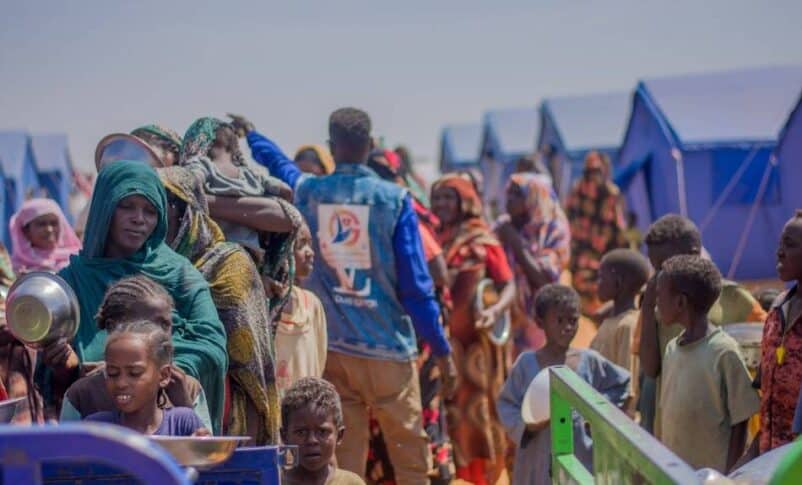 Displaced people from Bara queue to receive a meal at a displacement camp in El Obeid, North Kordofan, on October 23, 2025.