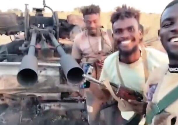 Sudanese troops stand near the wreckage of a vehicle, mounted with a heavy machinegun, on Nov. 16, 2025.