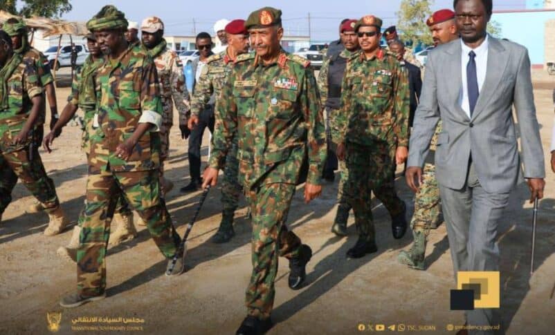 Al-Burhan (C) arrives for a memorial for SLA fighters in Port Sudan flaked by Minnawi (R) and his deputy commander on Dec 1, 2025