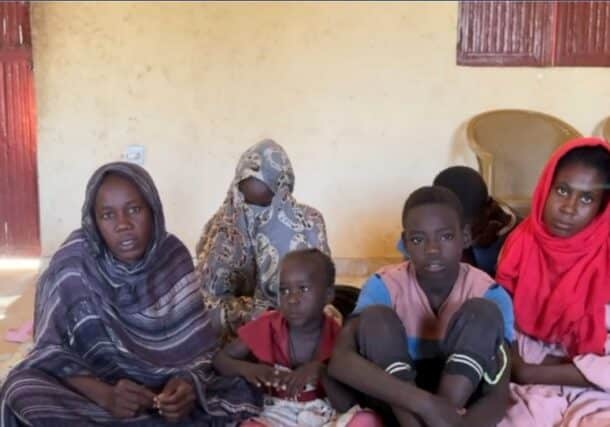 A displaced woman in Tawila with children who lost their parents during the fall of El Fasher.
