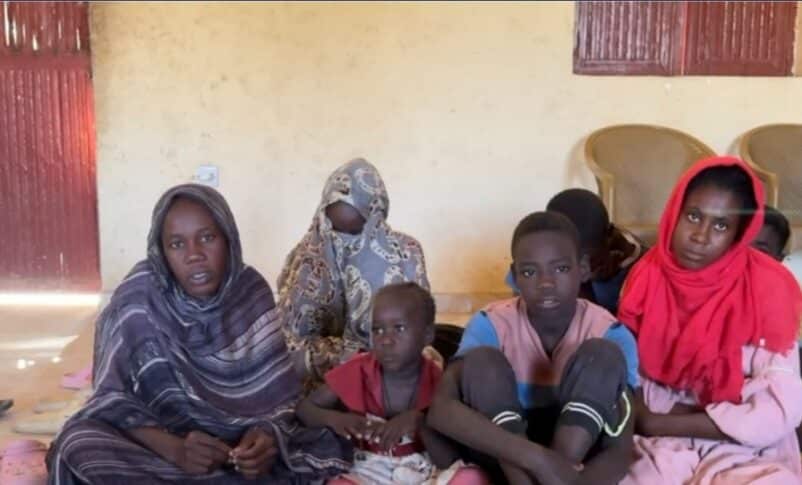 A displaced woman in Tawila with children who lost their parents during the fall of El Fasher.