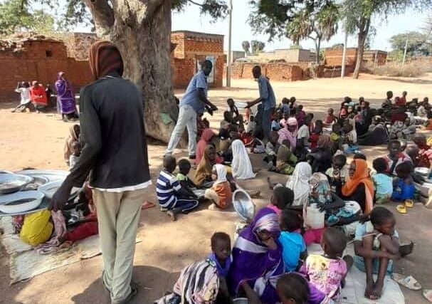 Aid volunteers distribute meals to local children at a community kitchen in Dilling, South Kordofan, Jan. 23, 2026.