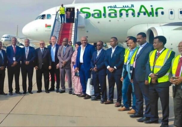 Officials and airport staff stand before a Salam Air aircraft during a welcoming ceremony at Khartoum International Airport, Jan 26, 2026