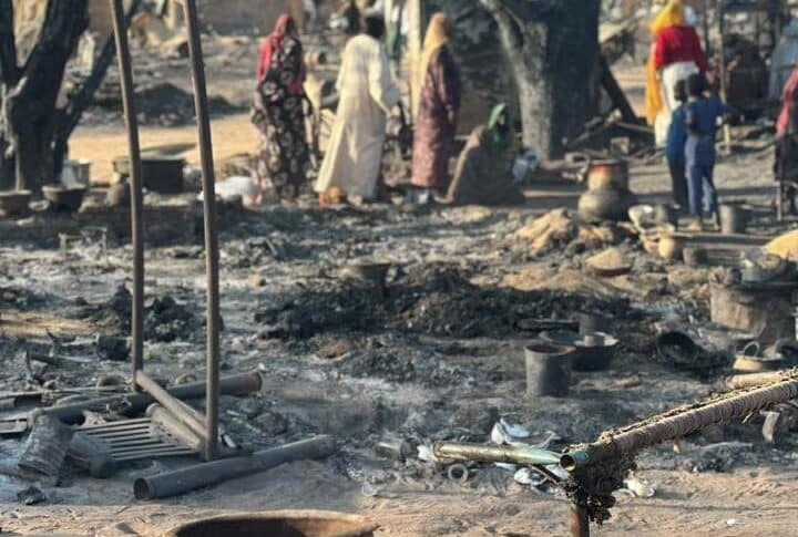 Displaced people inspect the charred remains of their belongings at Kalma camp in South Darfur on March 1, 2026, after a massive fire destroyed more than 1,000 makeshift shelters.