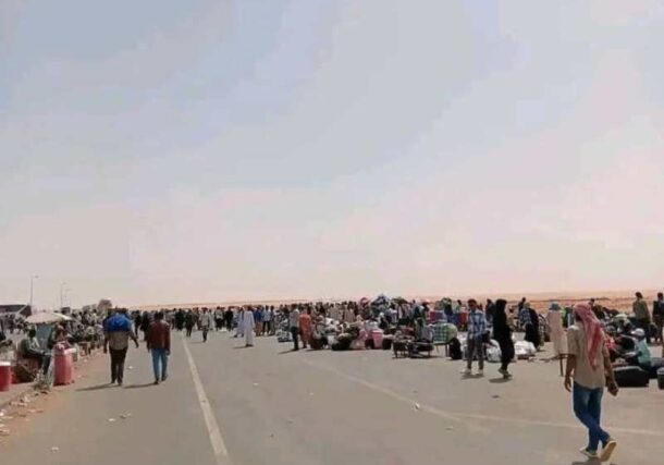 Sudanese returnees wait for transportation at the Arqin crossing on the border with Egypt after bus operators suspended a strike over tax hikes, March 27, 2026.