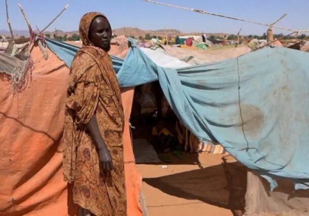 A Sudanese woman stands outside her makeshift shelter in a displacement camp in North Darfur. Reuters file photo