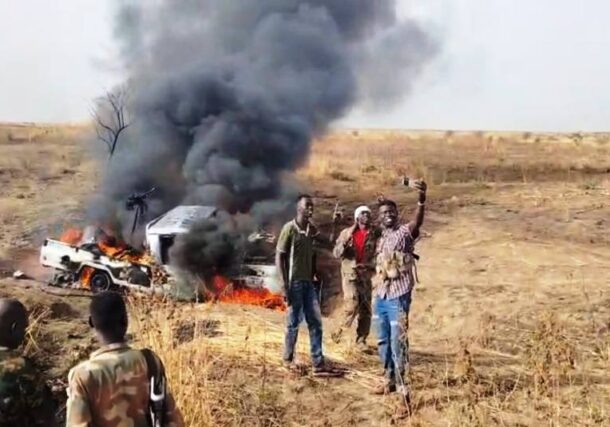 Sudanese army troops take a picture besides burning RFS vehicle in Al Tukma, South Kordofan on April 6, 2026..