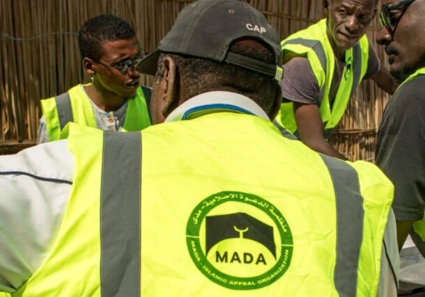 Islamic Dawa Organization workers discuss before to start food distribuntion to displaced people at Goz camp in the White Nile state on Dec 17, 2025