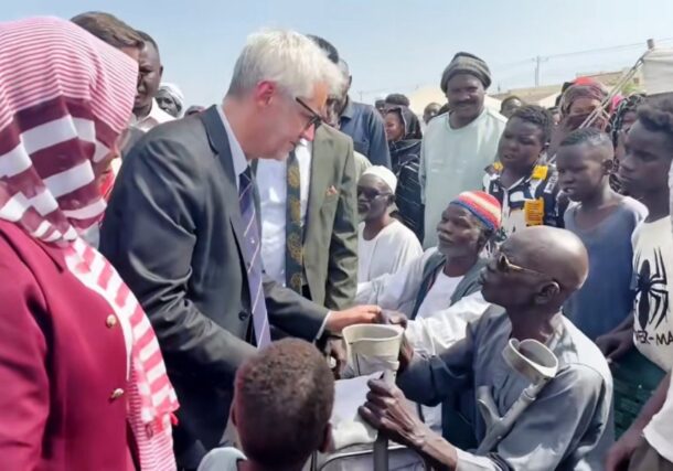 French lawmaker Christophe Marion spoeaks with residents of a displacement camp in Port Sudan on May 9, 2026