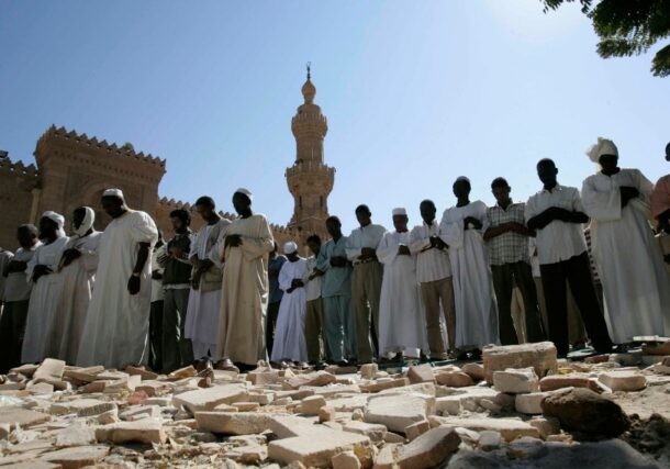Sudanese men take part in Friday prayers outside the Great Mosque in Khartoum