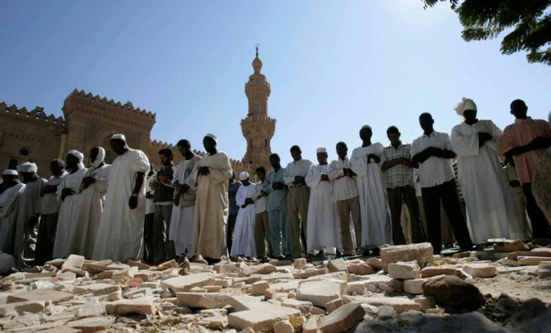 Sudanese men take part in Friday prayers outside the Great Mosque in Khartoum