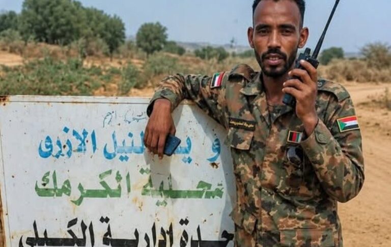 Sudanese military stands at a banner at the entrance of Al Kaily area on May 9, 2026