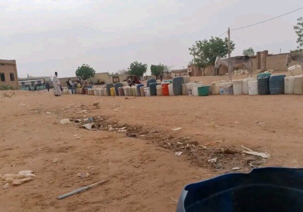 Containers and plastic jugs are lined up as people wait to collect water in El Obeid, Sudan, June 22, 2026