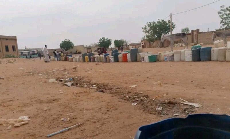 Containers and plastic jugs are lined up as people wait to collect water in El Obeid, Sudan, June 22, 2026