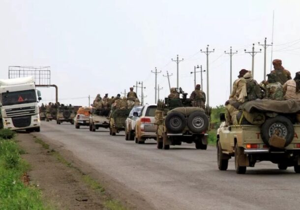 Fighters board vehicles of a military convoy in the eastern city of Gedaref, en route to Port Sudan, on August 30, 2023.