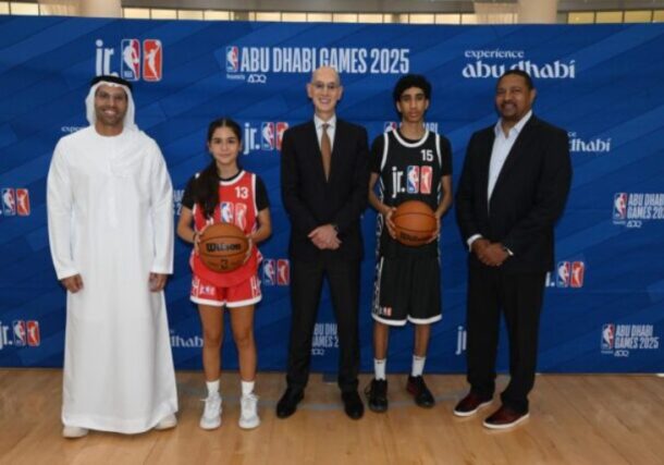 NBA Commissioner Adam Silver (center) poses with officials and young basketball players at an "Abu Dhabi Games 2025" event promoting the league's multi-year partnership with the United Arab Emirates.