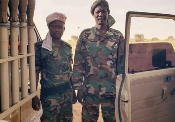 Former Sudanese rebel commander Abdallah Banda, right, poses in military fatigues after rejoining the Justice and Equality Movement (JEM) following the outbreak of conflict between the army and the Rapid Support Forces, in this handout image obtained from social media.