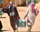 Displaced women carry humanitarian aid supplies in Khartoum, Sudan. (SPA photo)