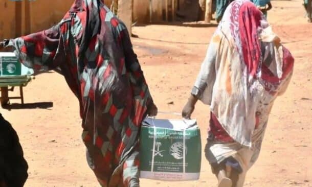 Displaced women carry humanitarian aid supplies in Khartoum, Sudan. (SPA photo)