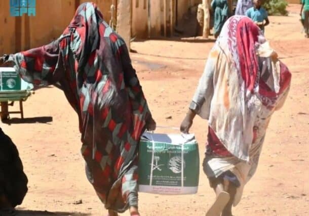 Displaced women carry humanitarian aid supplies in Khartoum, Sudan. (SPA photo)
