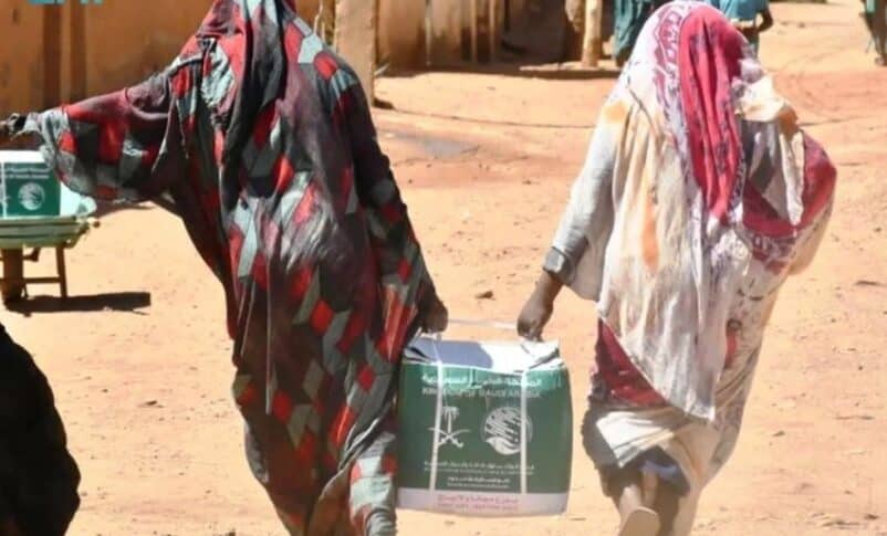 Displaced women carry humanitarian aid supplies in Khartoum, Sudan. (SPA photo)