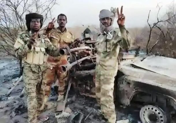 Joint Force members stand next to a destroyed RSF vehicle in Amburu, North Darfur, Aug. 13, 2026.