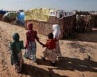 Sudanese girls who fled the conflict in Darfur walk beside makeshift shelters holding each other's hands in Adre, Chad, in 2023. Reuters photo