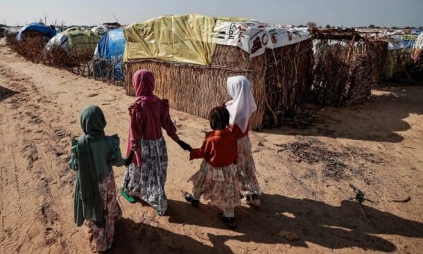 Sudanese girls who fled the conflict in Darfur walk beside makeshift shelters holding each other's hands in Adre, Chad, in 2023. Reuters photo