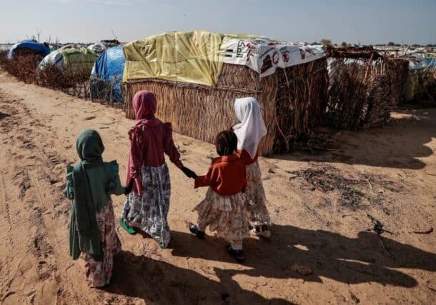 Sudanese girls who fled the conflict in Darfur walk beside makeshift shelters holding each other's hands in Adre, Chad, in 2023. Reuters photo
