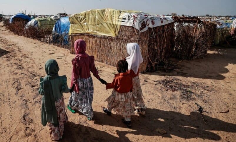 Sudanese girls who fled the conflict in Darfur walk beside makeshift shelters holding each other's hands in Adre, Chad, in 2023. Reuters photo