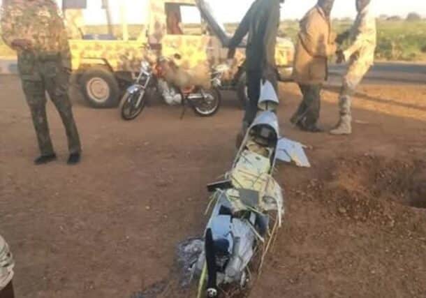 Sudanese soldier drags the wreckage of a downed drone across a field in White Nile State, Sudan, January 22, 2025