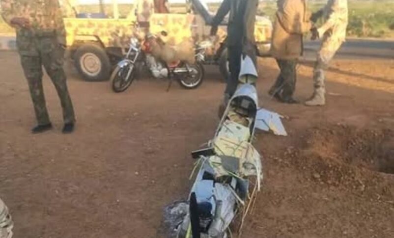 Sudanese soldier drags the wreckage of a downed drone across a field in White Nile State, Sudan, January 22, 2025